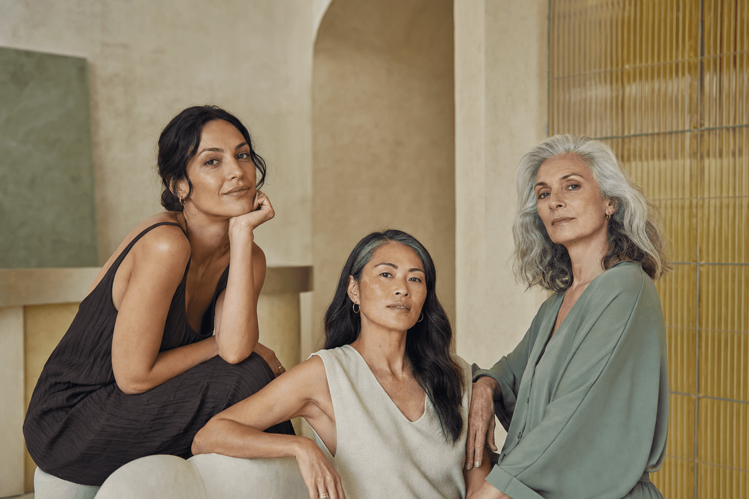 Tre donne adulte di età e tonalità di pelle diverse in uno studio luminoso